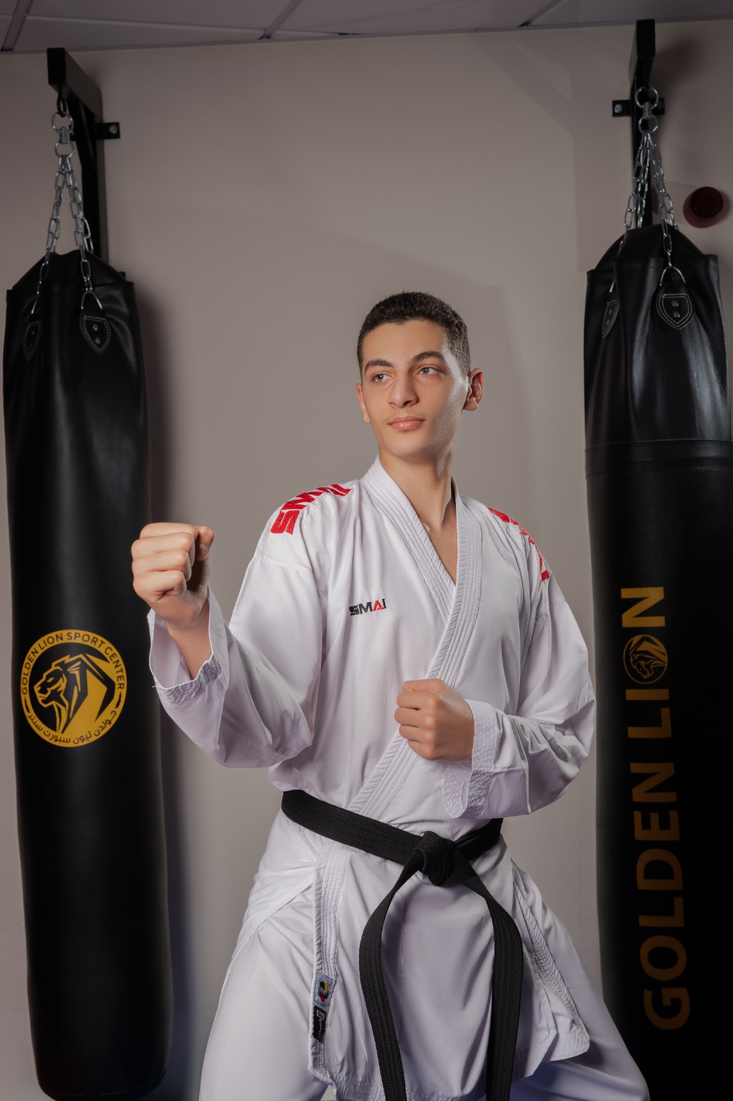 Teen student in fighting stance wearing a black belt