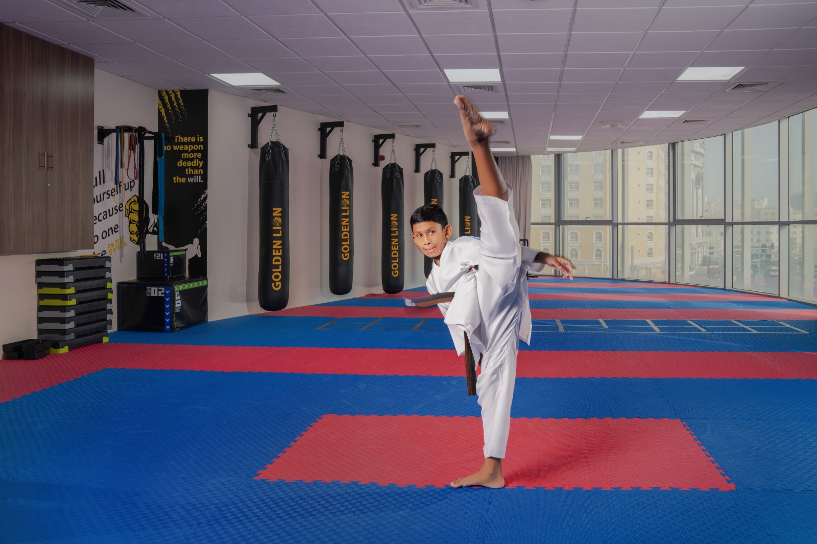 Young student throwing a high kick on the Golden Lion mat